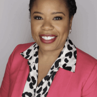Kristen Dufauchard smiling at the camera against a gray background.